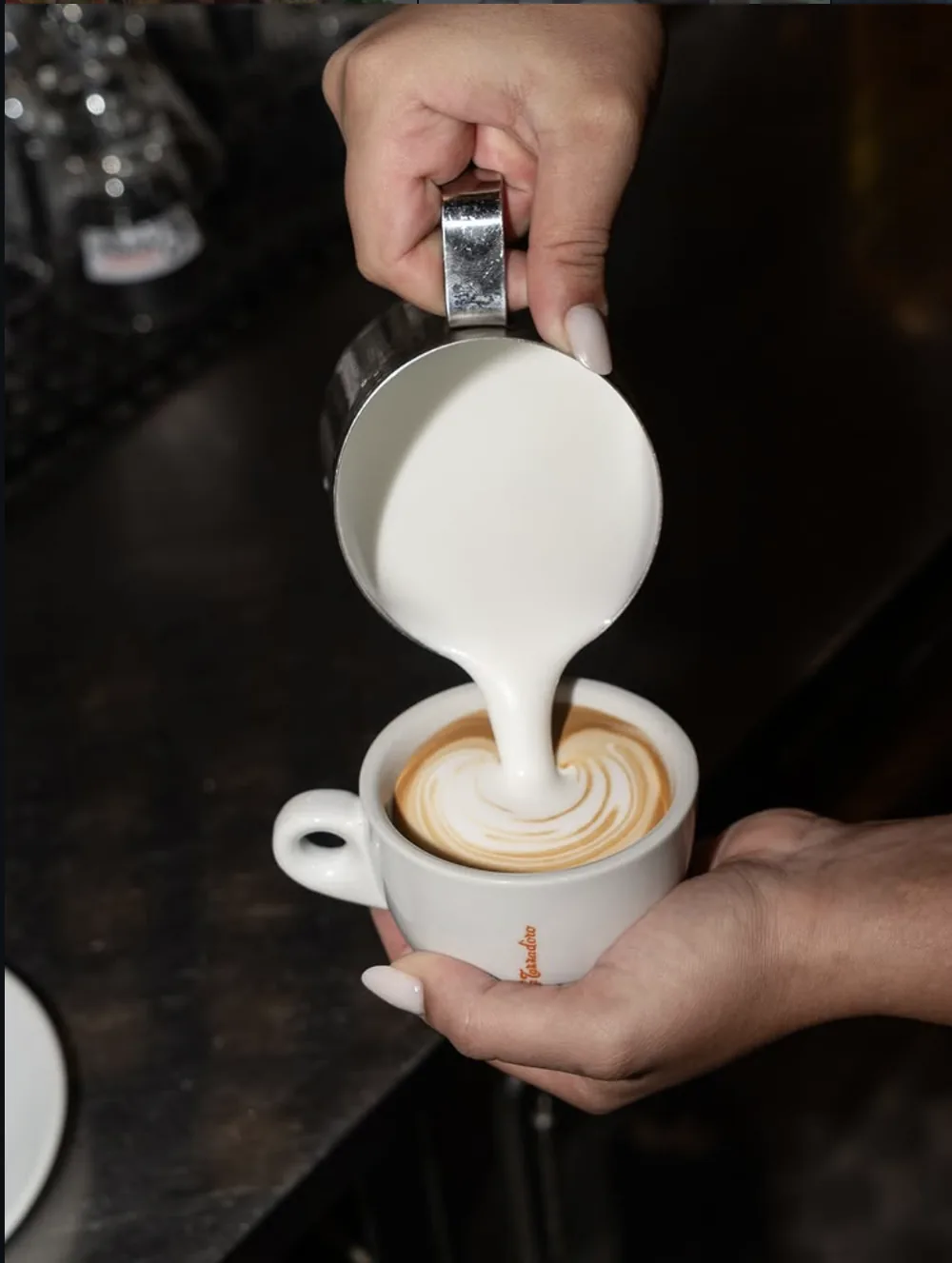 Cappuccino con latte art versato al banco